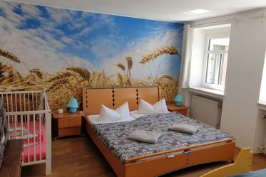 Schlafzimmer mit Doppelbett, Bett in Rennauto-Optik und Babybett