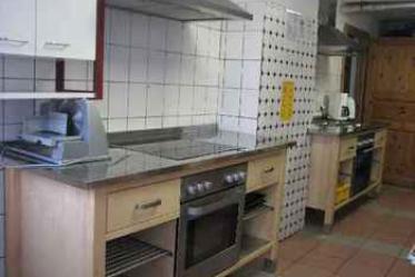 Küche mit 2 Elektroherden, Mikrowelle, Spülmaschine und Kühlung in Speisekammer.